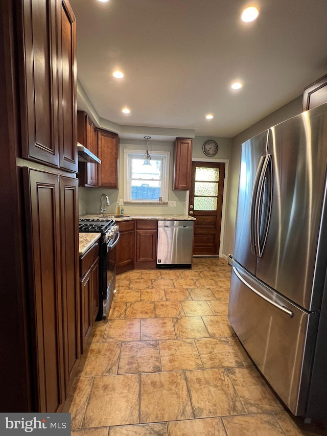 kitchen with stainless steel appliances, wall chimney range hood, recessed lighting, light stone finish floors, and a sink