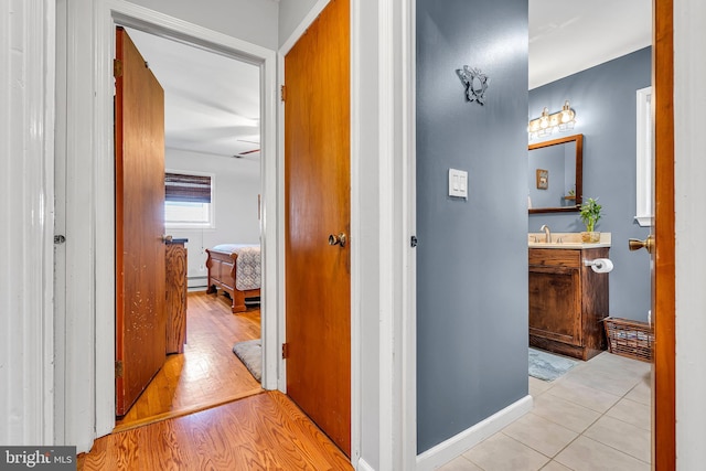 16 Bayberry Dr, Lanoka Harbor, NJ 08734 - hallway with baseboard heating, a sink, wood finished floors, and baseboards