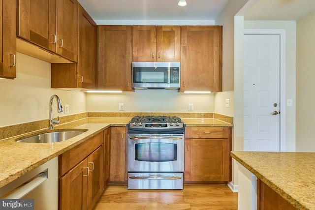 2200 N Westmoreland St Unit 325, Arlington, VA 22213 - kitchen with appliances with stainless steel finishes, light stone counters, light wood finished floors, and brown cabinetry