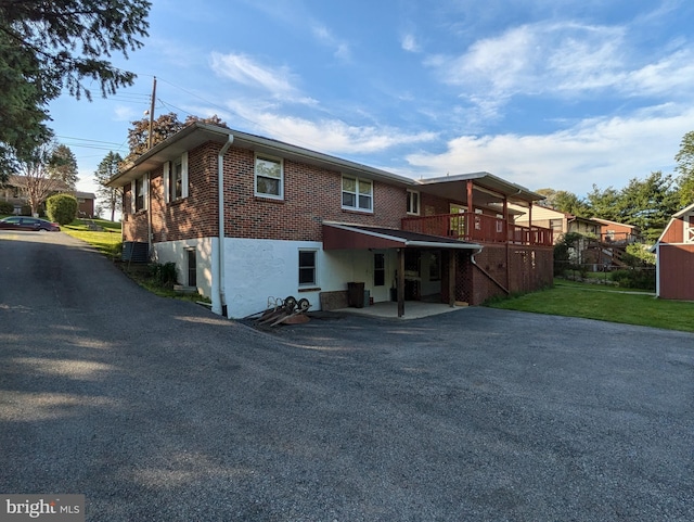 671 Woodview St, Steelton, PA 17113 - back of property with driveway, brick siding, central air condition unit, and a yard