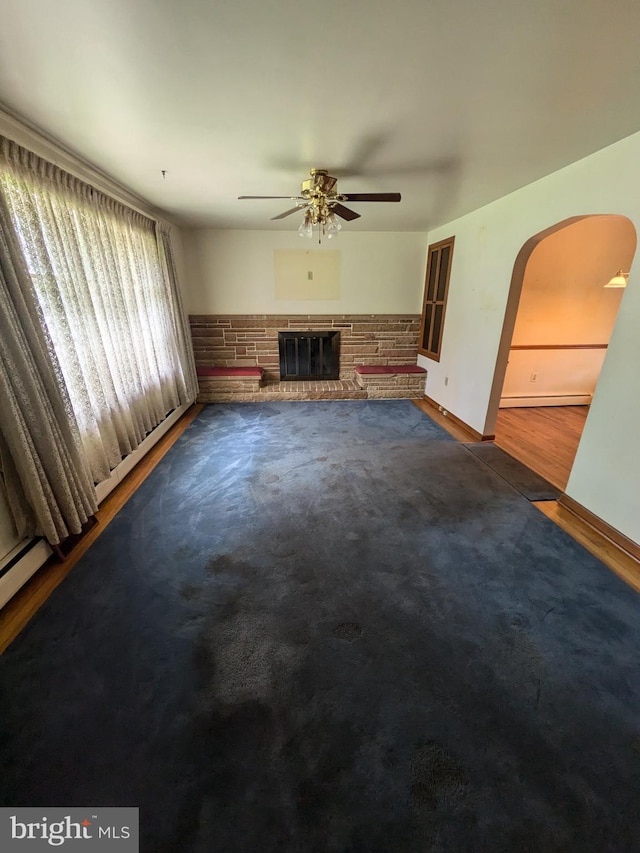 671 Woodview St, Steelton, PA 17113 - unfurnished living room with a ceiling fan, arched walkways, a fireplace, baseboards, and carpet