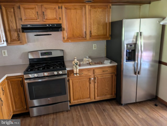 671 Woodview St, Steelton, PA 17113 - kitchen with appliances with stainless steel finishes, under cabinet range hood, light countertops, brown cabinets, and wood finished floors