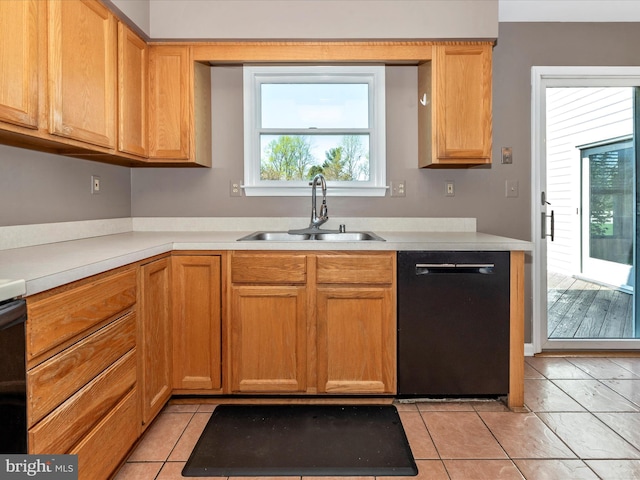 kitchen featuring a sink, dishwasher, light countertops, and light tile patterned flooring
