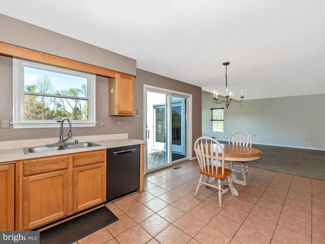 kitchen featuring black dishwasher, a sink, a chandelier, and light countertops