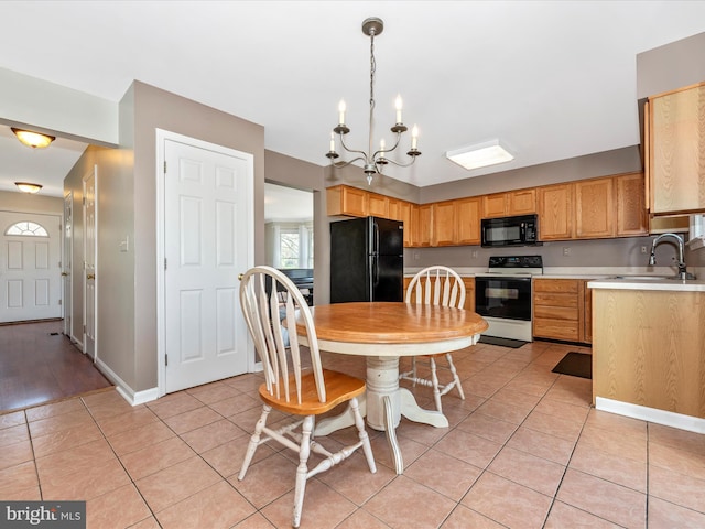 kitchen featuring black appliances, a sink, light countertops, a chandelier, and light tile patterned flooring