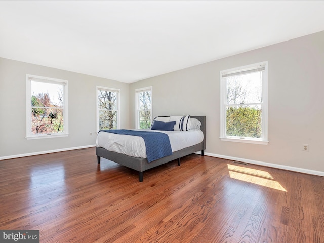 bedroom with baseboards and wood finished floors