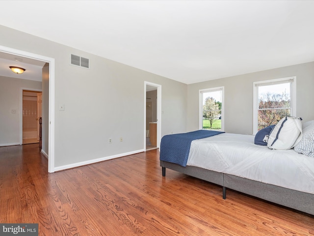bedroom with wood finished floors and baseboards