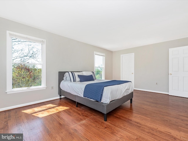 bedroom with baseboards and wood finished floors