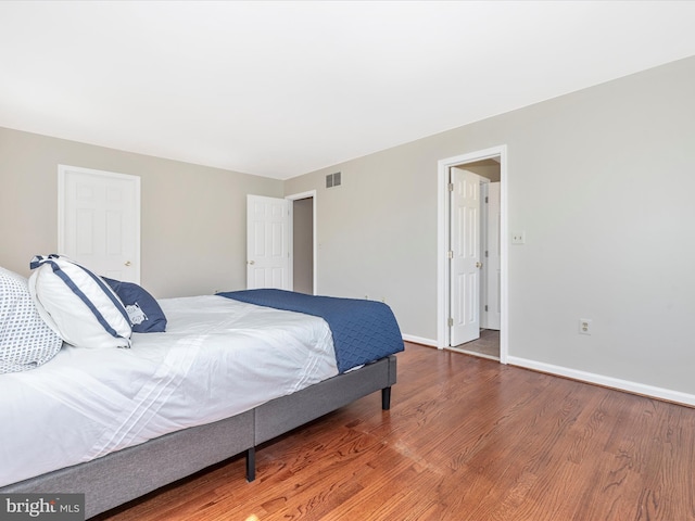 bedroom with wood finished floors and baseboards