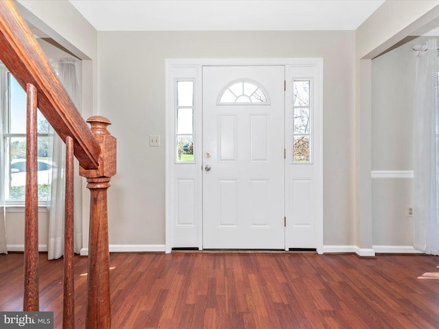 entryway with dark wood-style flooring, healthy amount of natural light, and baseboards