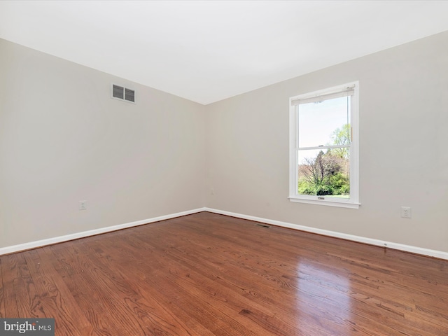 unfurnished room with baseboards and wood finished floors