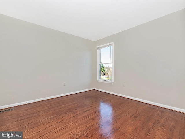 empty room featuring baseboards and wood finished floors