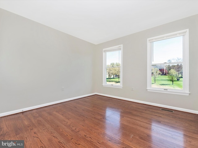 unfurnished room with baseboards and wood finished floors