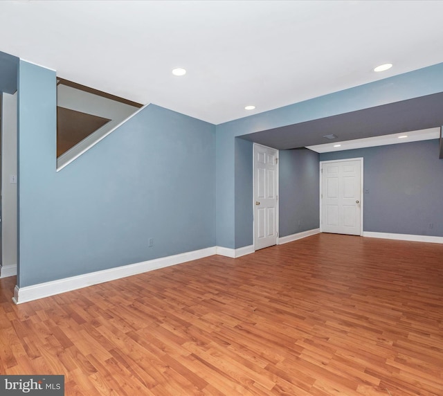finished below grade area featuring light wood-style floors, baseboards, and recessed lighting