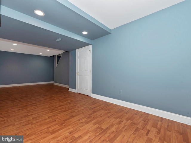 empty room featuring baseboards, light wood finished floors, and recessed lighting