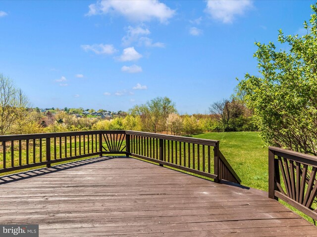 wooden deck featuring a lawn