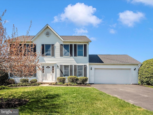 view of front of home with driveway, a garage, a front yard, and roof with shingles
