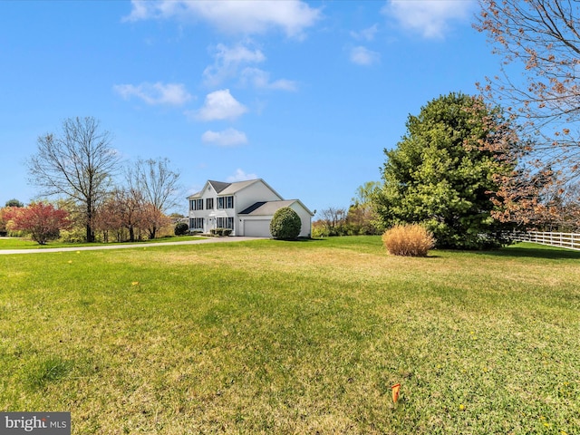 view of yard with an attached garage and driveway
