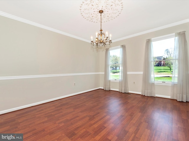 unfurnished room with a chandelier, dark wood-style flooring, baseboards, and ornamental molding