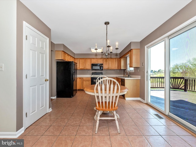 kitchen with black appliances, light countertops, healthy amount of natural light, and baseboards