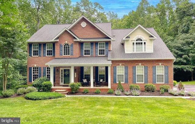 9150 Sparkling Pl, Charlotte Hall, MD 20622 - colonial-style house featuring a front yard, covered porch, brick siding, and a shingled roof