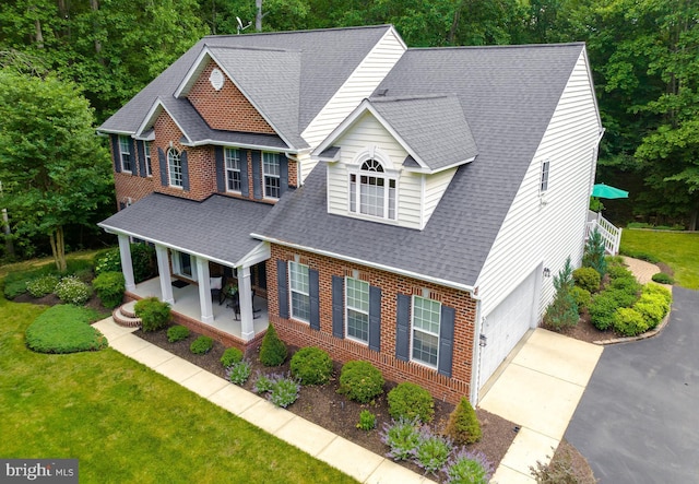 9150 Sparkling Pl, Charlotte Hall, MD 20622 - view of front facade featuring concrete driveway, brick siding, a garage, a front lawn, and roof with shingles