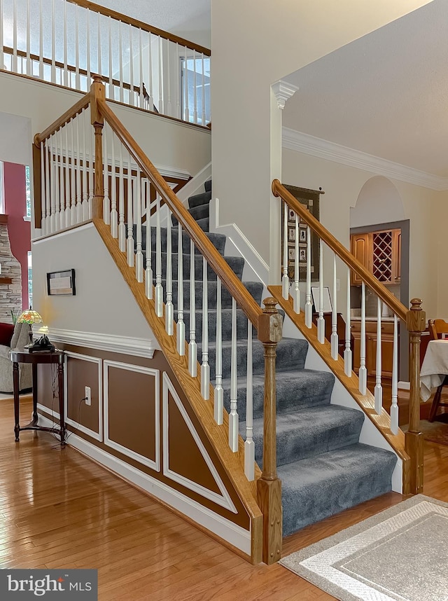 9150 Sparkling Pl, Charlotte Hall, MD 20622 - stairs featuring wood finished floors, ornamental molding, and a towering ceiling