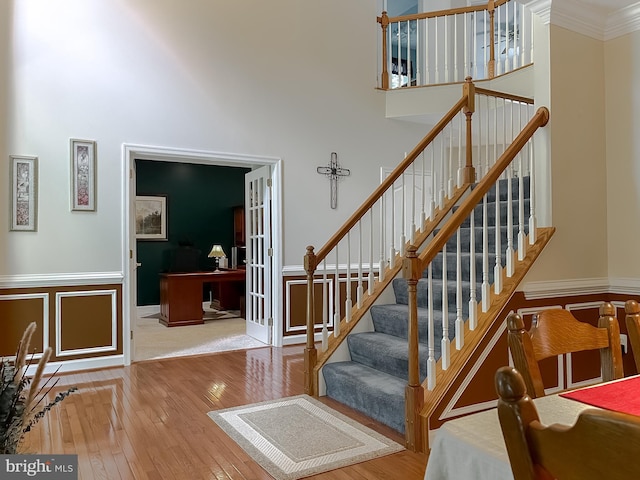 9150 Sparkling Pl, Charlotte Hall, MD 20622 - staircase with a high ceiling, hardwood / wood-style floors, ornamental molding, and a wainscoted wall