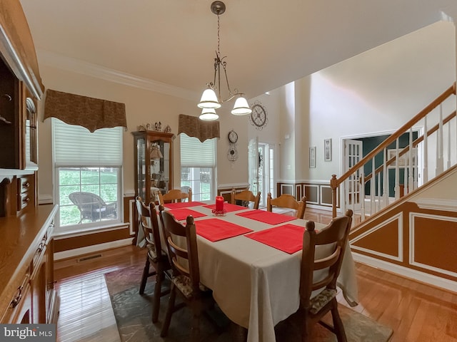 9150 Sparkling Pl, Charlotte Hall, MD 20622 - dining area featuring healthy amount of natural light, a wainscoted wall, ornamental molding, wood finished floors, and stairway
