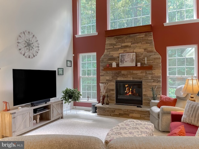 9150 Sparkling Pl, Charlotte Hall, MD 20622 - carpeted living area with a high ceiling, a stone fireplace, and baseboards