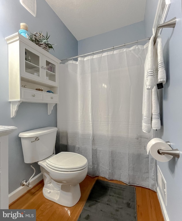 9150 Sparkling Pl, Charlotte Hall, MD 20622 - full bath featuring wood finished floors, toilet, a shower with curtain, and baseboards