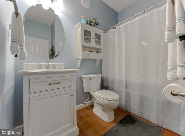 9150 Sparkling Pl, Charlotte Hall, MD 20622 - full bathroom featuring wood finished floors, toilet, vanity, baseboards, and a shower with curtain