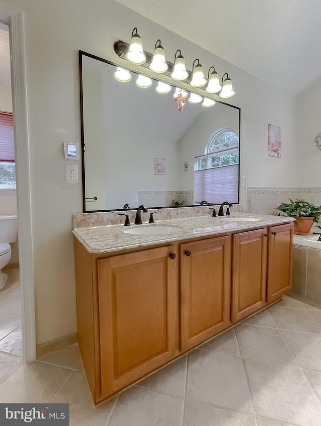 9150 Sparkling Pl, Charlotte Hall, MD 20622 - bathroom featuring tile patterned floors, lofted ceiling, toilet, double vanity, and a bath
