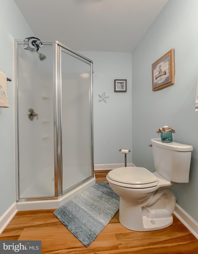 9150 Sparkling Pl, Charlotte Hall, MD 20622 - bathroom featuring toilet, a stall shower, baseboards, and wood finished floors