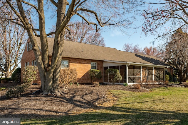 904 W Main St, New Holland, PA 17557 - back of house with a sunroom, roof with shingles, a lawn, and brick siding