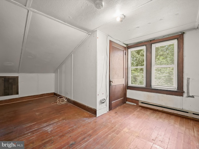1812 64th Ave, Landover, MD 20785 - additional living space with wood-type flooring, vaulted ceiling, a baseboard radiator, and a textured ceiling