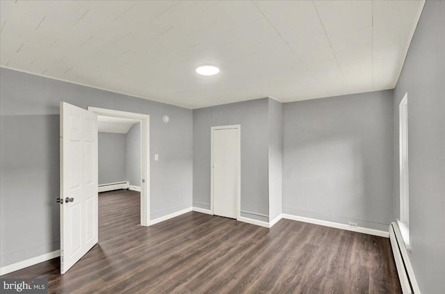613 Minor St, Reading, PA 19602 - unfurnished room with a baseboard heating unit, dark wood-style flooring, and baseboards