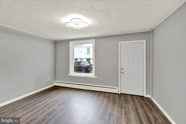 613 Minor St, Reading, PA 19602 - entrance foyer with a baseboard heating unit, wood finished floors, crown molding, baseboards, and wood walls