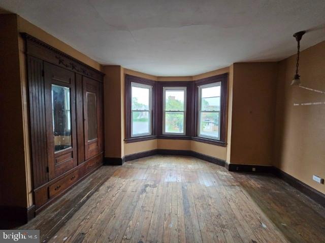 unfurnished bedroom with hardwood / wood-style flooring and baseboards