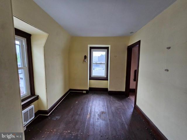 empty room featuring wood-type flooring and baseboards