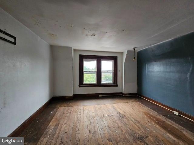 bonus room with wood-type flooring and baseboards
