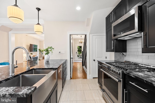 429 Manor Pl NW, Washington, DC 20010 - kitchen featuring stainless steel appliances, a sink, dark cabinets, tasteful backsplash, and dark stone counters