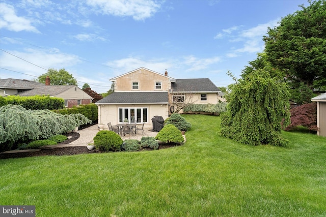 back of property featuring a patio area, a yard, and stucco siding