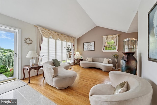 living area with vaulted ceiling and wood finished floors