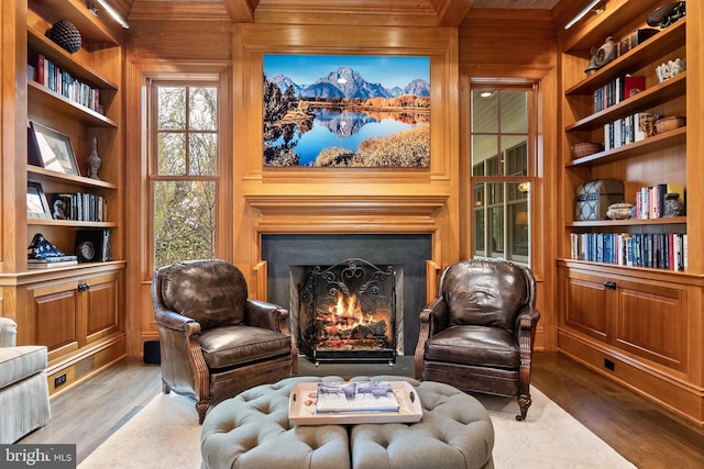 6529 Sothoron Rd, Mclean, VA 22101 - living area with wood walls, wood finished floors, built in shelves, a lit fireplace, and crown molding