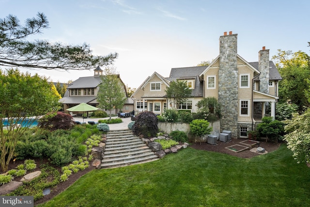 6529 Sothoron Rd, Mclean, VA 22101 - rear view of house featuring a lawn, stone siding, central AC, and a chimney