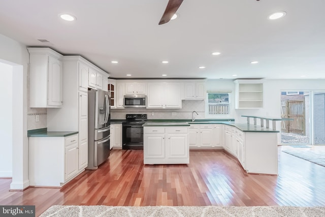 5923 Westridge Ct, Alexandria, VA 22310 - kitchen with appliances with stainless steel finishes, a peninsula, light wood-type flooring, white cabinets, and recessed lighting