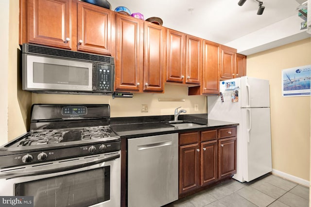 2633 Adams Mill Rd NW Unit 103, Washington, DC 20009 - kitchen with stainless steel appliances, a sink, light tile patterned floors, and baseboards
