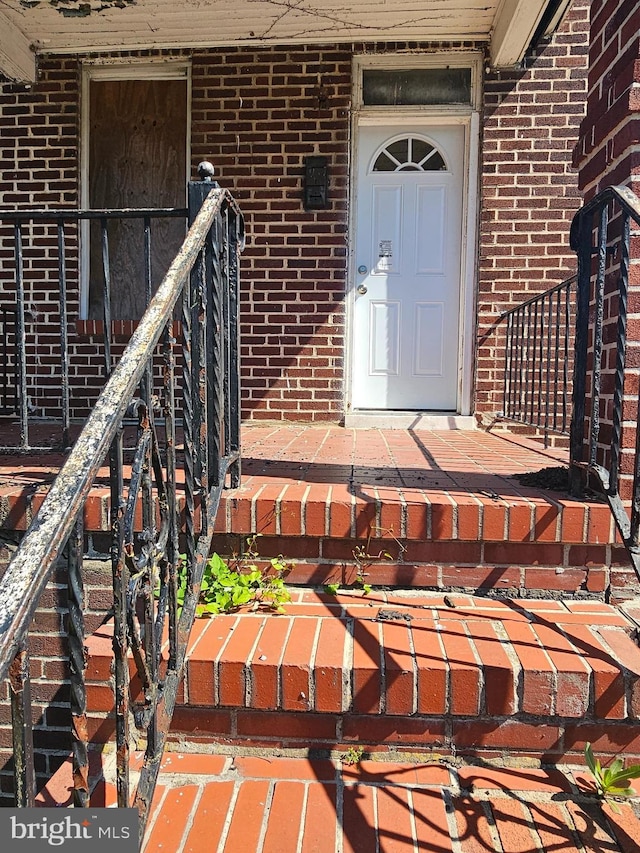entrance to property featuring brick siding