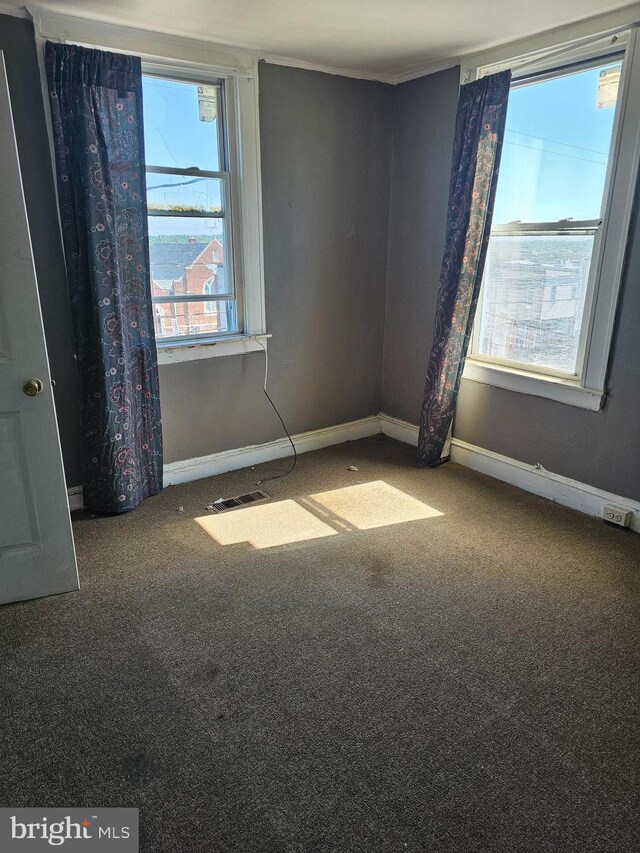 carpeted empty room featuring baseboards